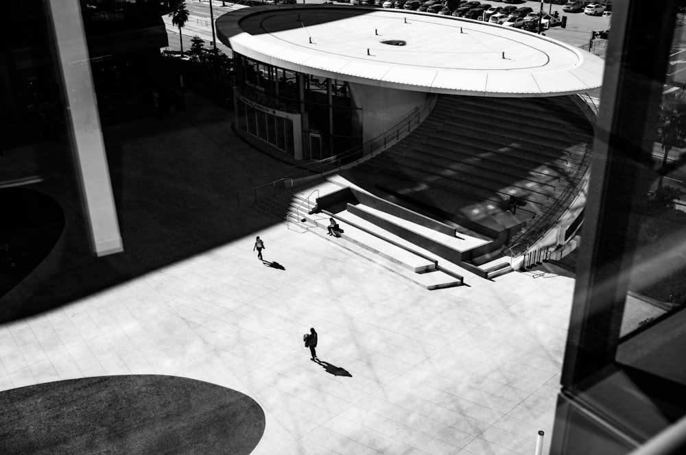 a black and white photo of people walking in front of a building