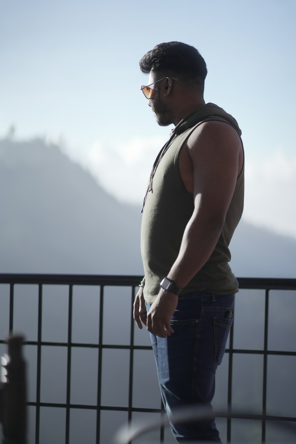 a man standing on top of a balcony next to a railing