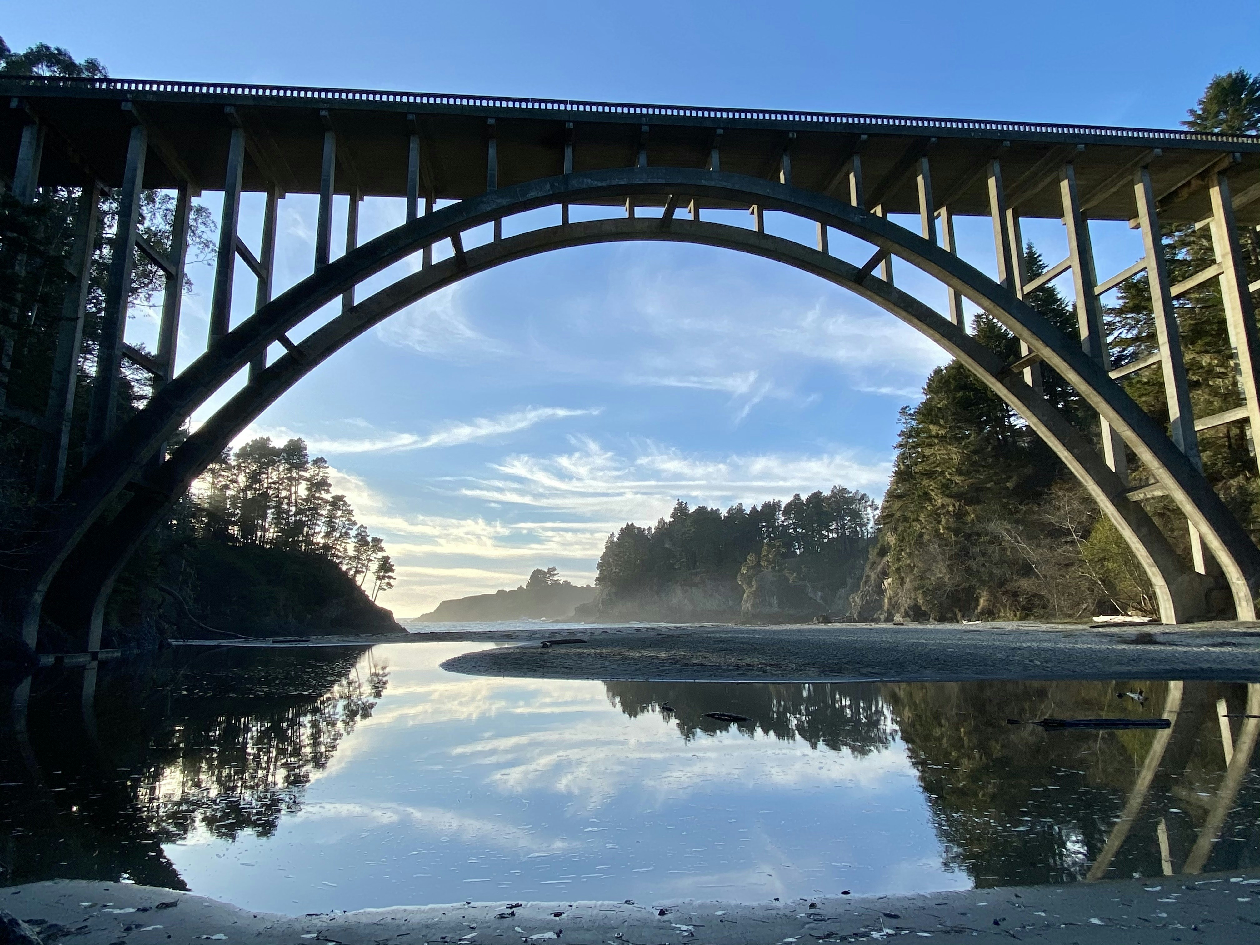 eine Brücke über ein Gewässer mit Bäumen im Hintergrund