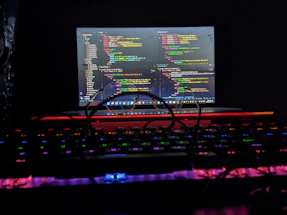 A friendly network engineer typing on a laptop with colorful code and network diagrams glowing on the screen.