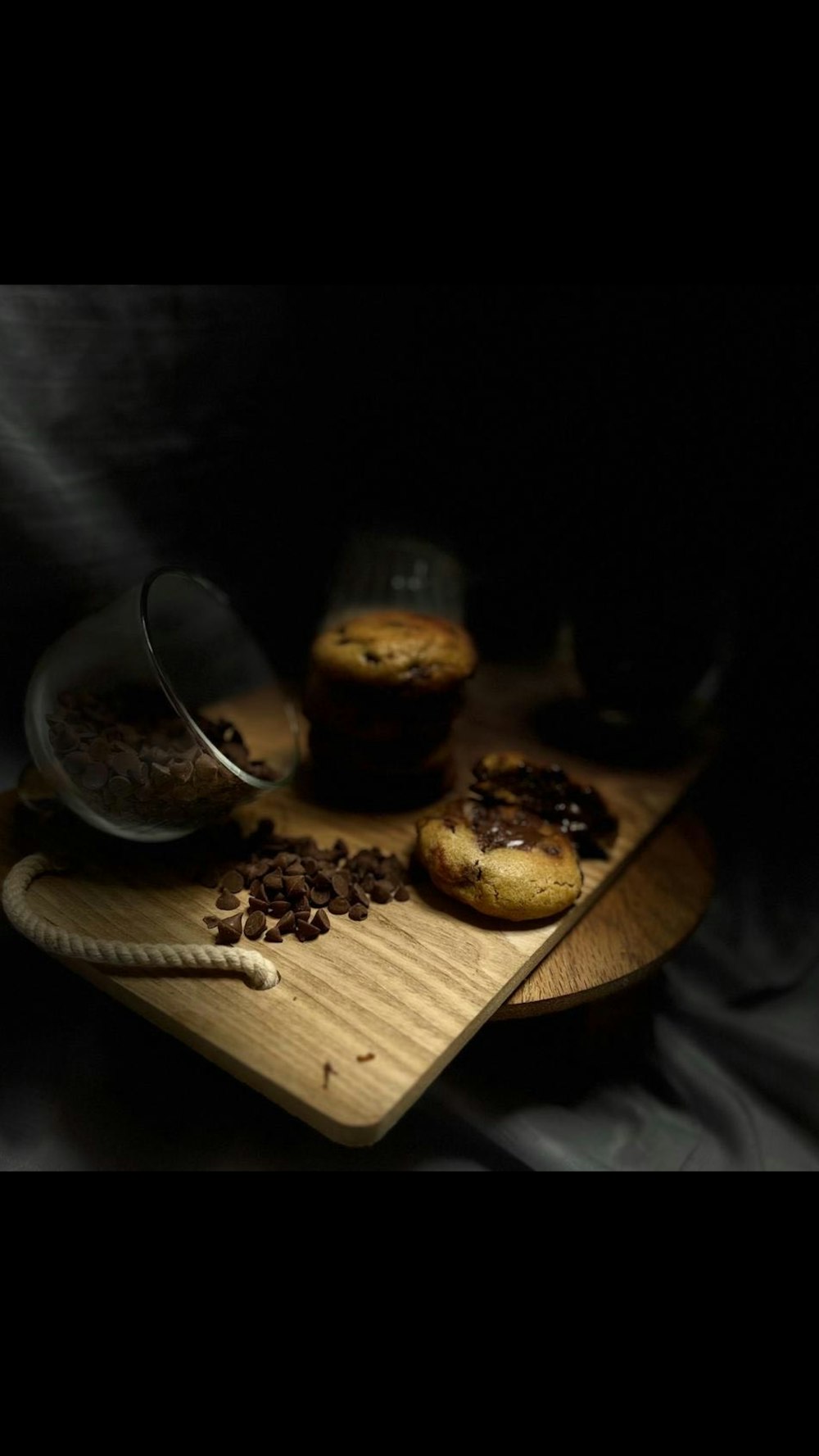 a wooden cutting board topped with muffins and chocolate chips