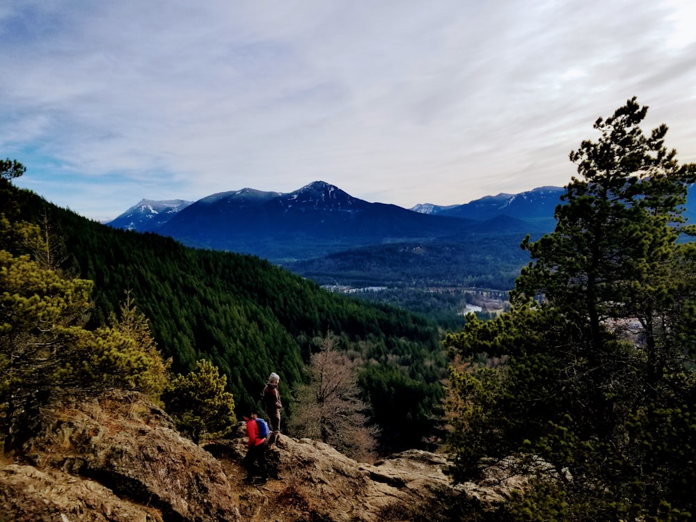 a couple of people sitting on top of a mountain