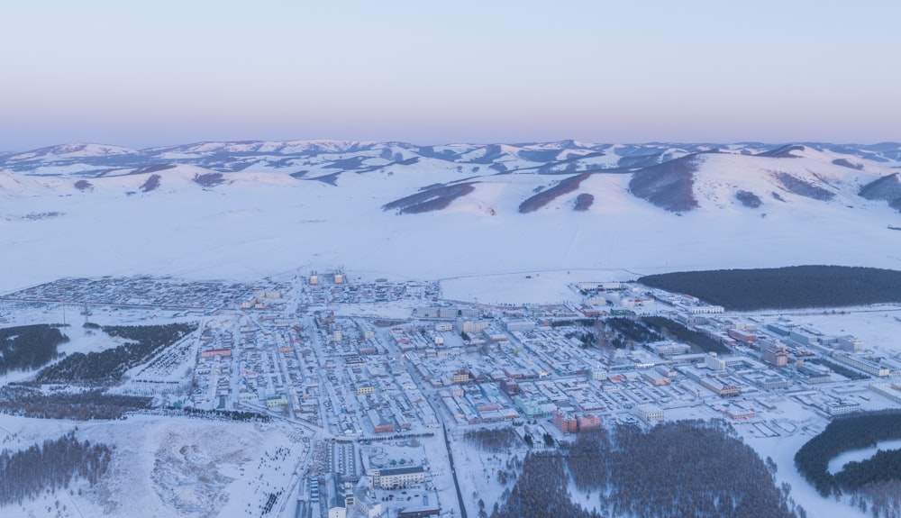 Una vista aérea de una ciudad rodeada de montañas cubiertas de nieve