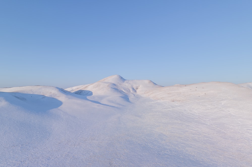 Una montaña cubierta de nieve con un cielo azul en el fondo