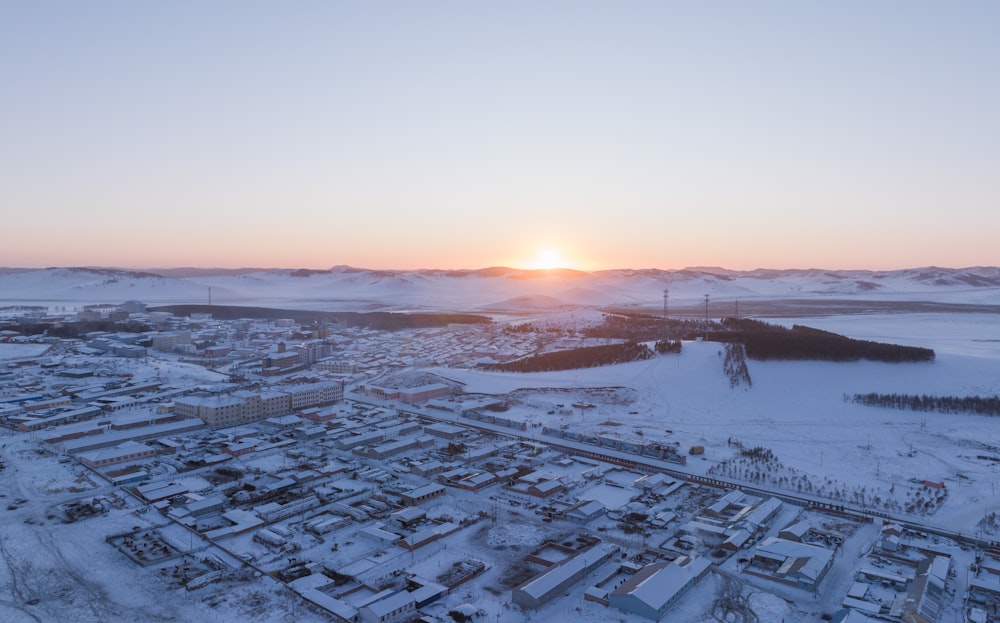the sun is setting over a snowy city