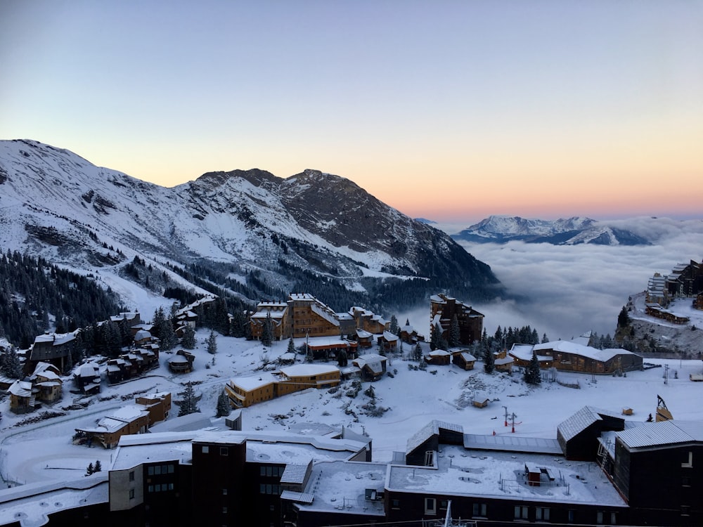 a view of a snowy mountain town with a mountain range in the background