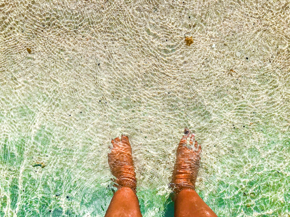 a person standing in the water with their feet in the water