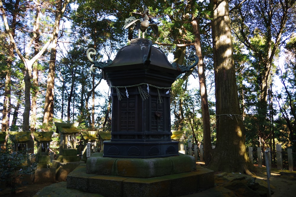 a clock tower sitting in the middle of a forest