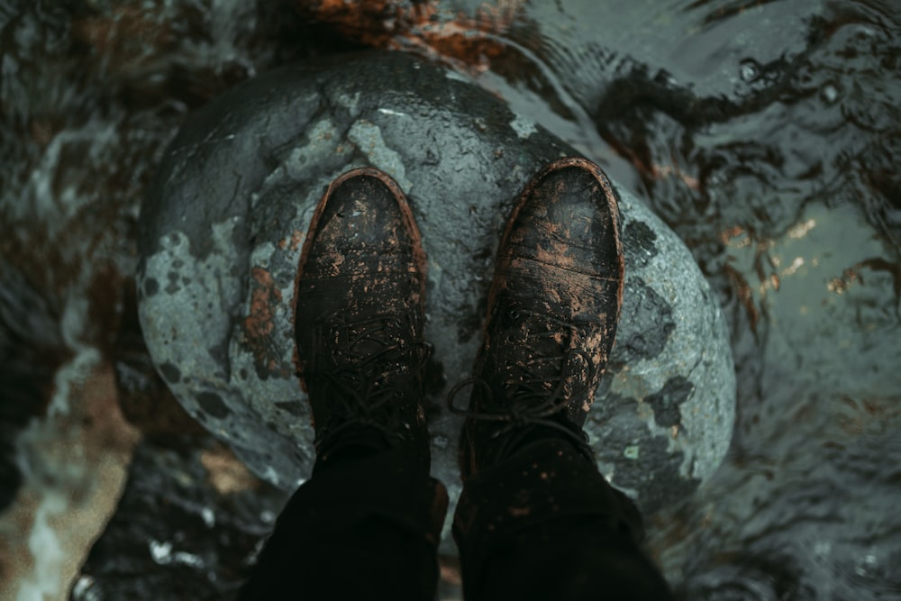 a person standing on a rock in the water