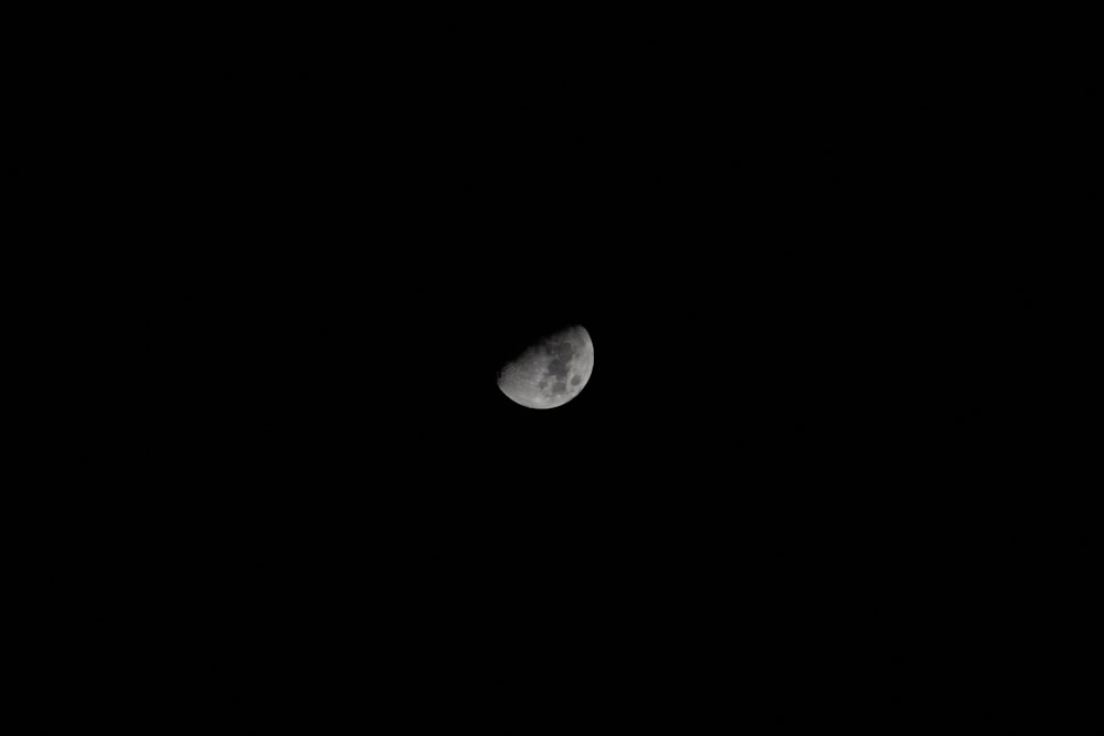 the moon is seen through the dark night sky