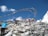 Group of climbers celebrating at a mountain summit with prayer flags fluttering