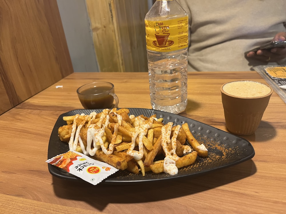 a plate of french fries and a drink on a table