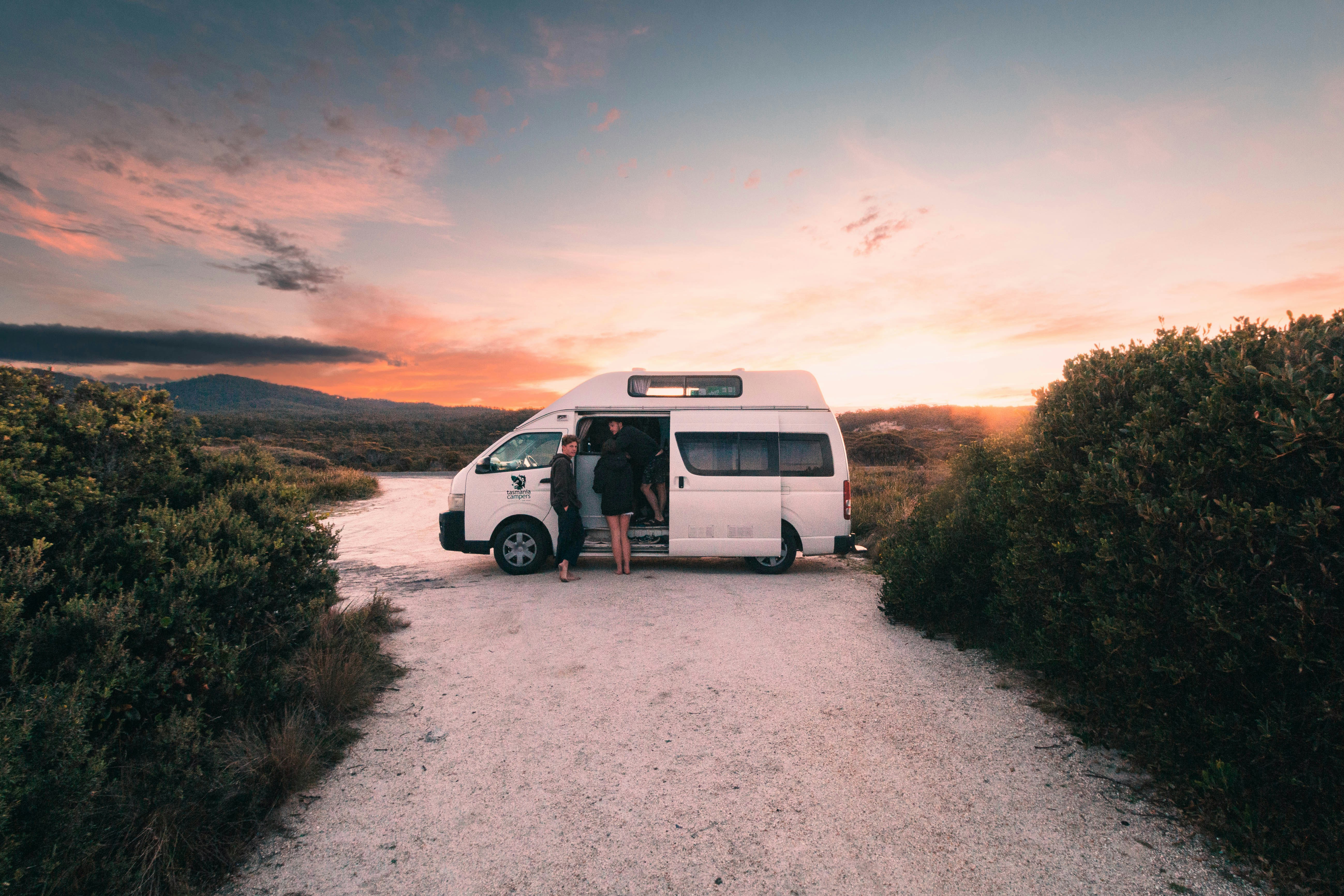 a white van parked on a dirt road, Watching the sunset from bay of fires, Tasmania.
