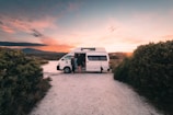 a white van parked on a dirt road