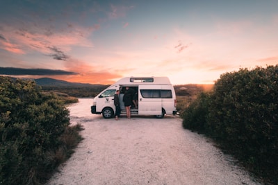 a white van parked on a dirt road