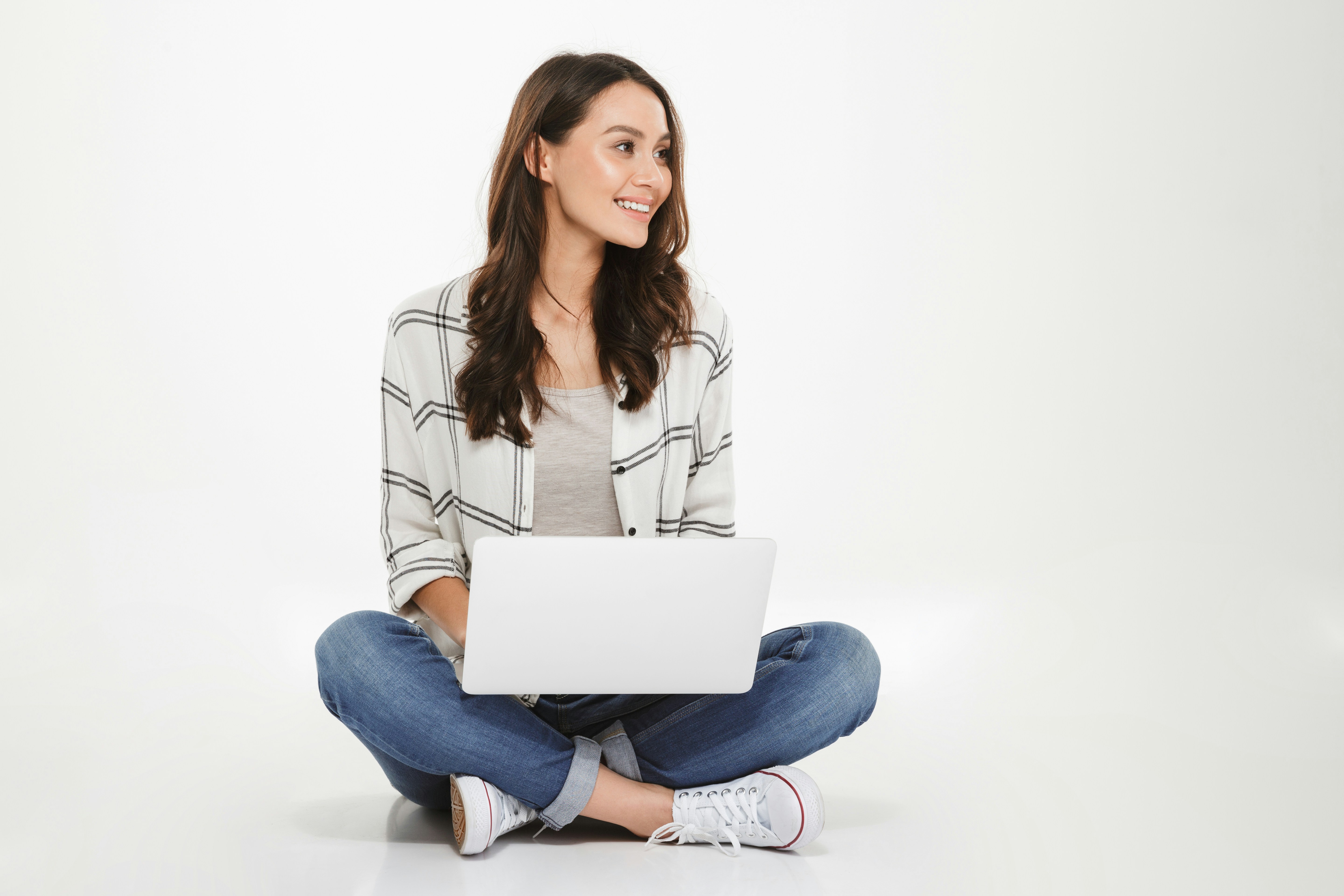 a woman sitting on the floor with a laptop