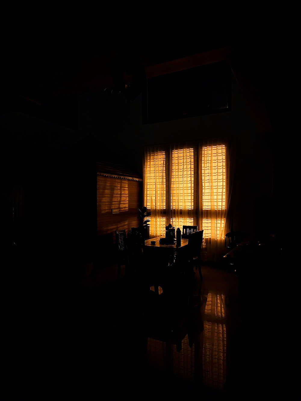 a dark room with a table and chairs in it