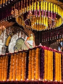 Elegant marigold and rose garlands draped around a traditional wedding mandap