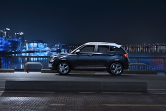 A sleek deep blue premium SUV parked against a modern Dubai skyline at dusk.