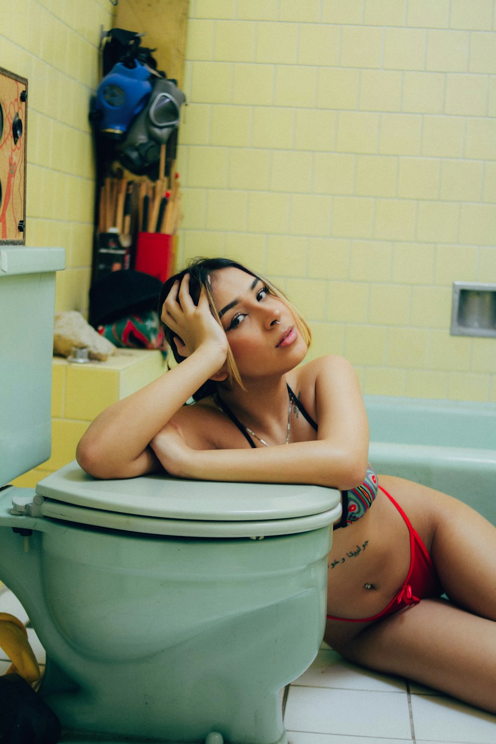 a woman in a bikini sitting on a toilet