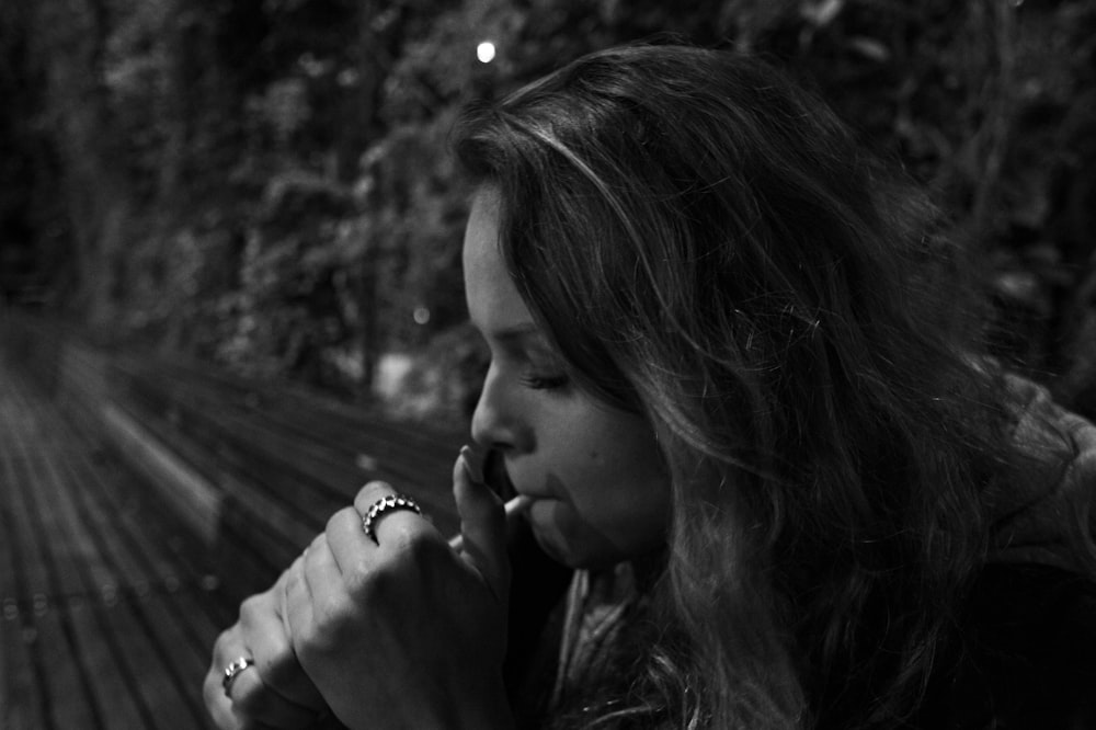 a woman sitting on a bench talking on a cell phone