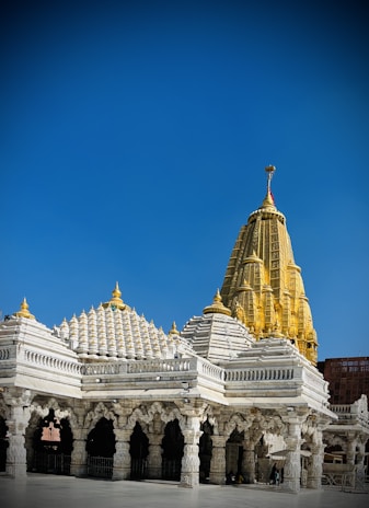 The golden dome of the Tirumala temple shining brightly against a clear blue sky.