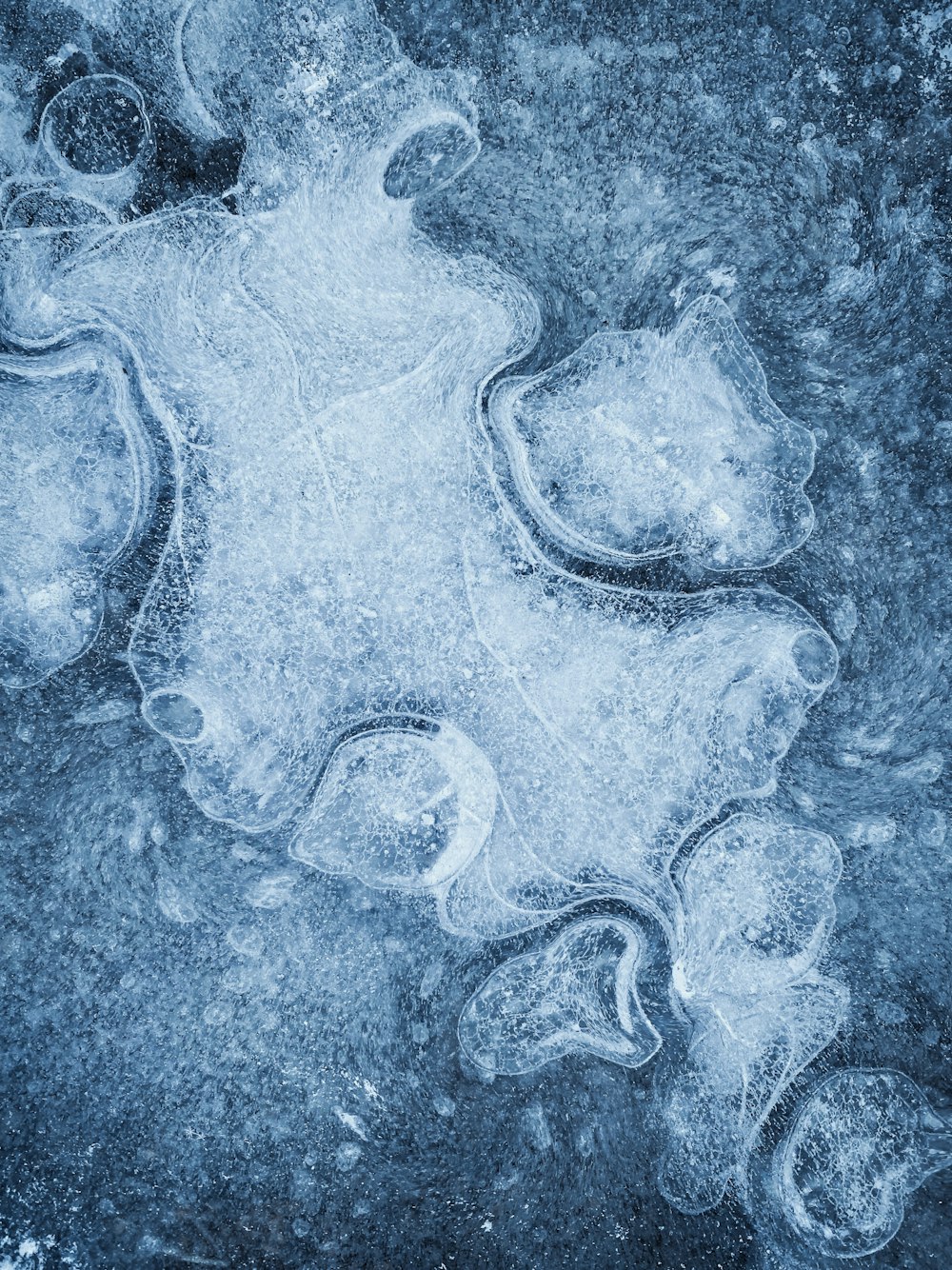 a frozen surface with ice and water bubbles