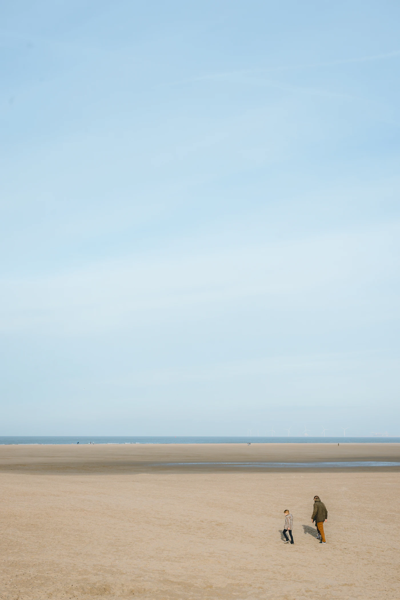 Moeder en kind vliegeren op het strand