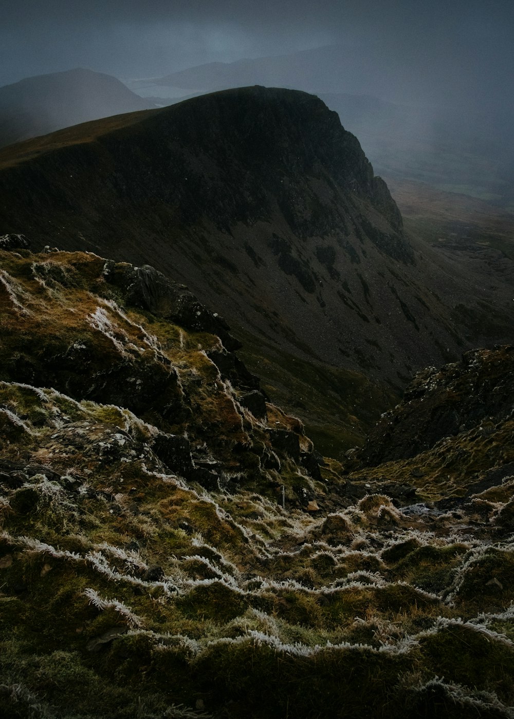 a mountain with a very dark sky in the background