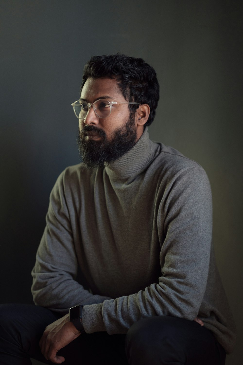 a man with a beard and glasses sitting down
