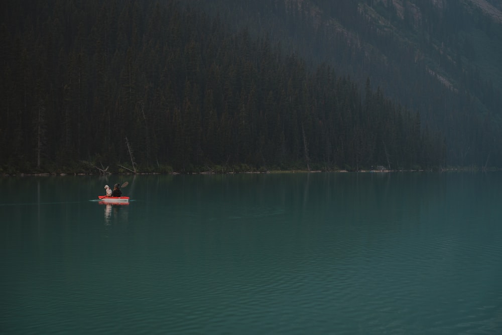 a person in a small boat on a lake