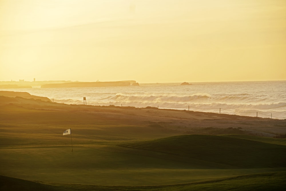 Le soleil se couche sur l’océan et un parcours de golf