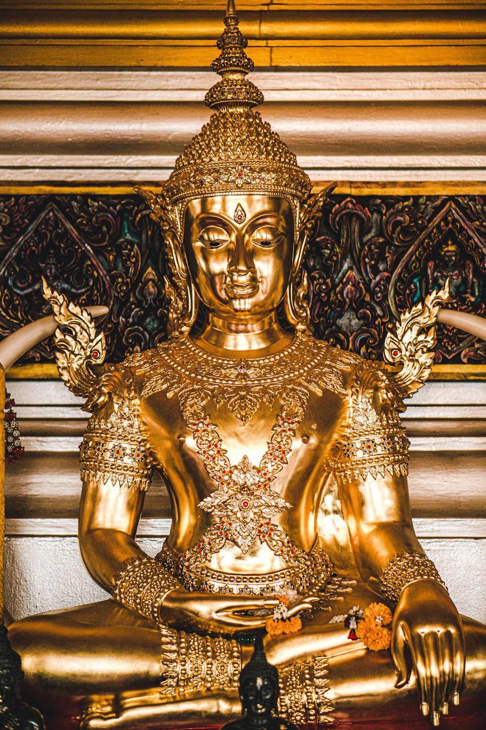 a large golden buddha statue sitting on top of a wooden table