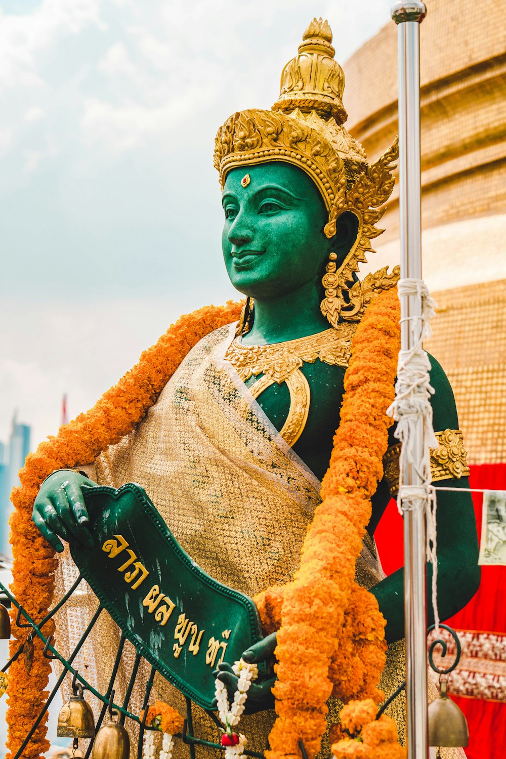 una estatua de una persona vestida de verde y oro