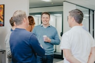 a group of people standing around talking to each other