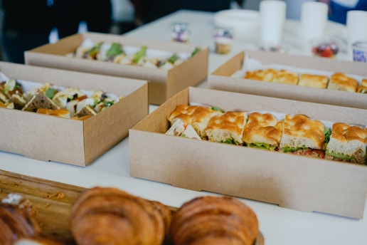 A professional catering setup at a corporate event with neatly packed meal boxes.