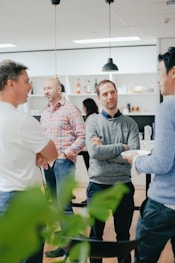 a group of men standing around a kitchen