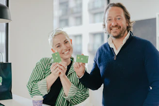 a man and a woman holding up small cards