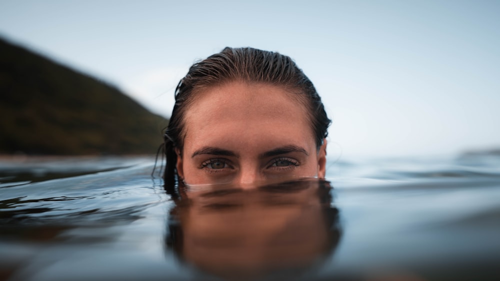 a close up of a person swimming in a body of water