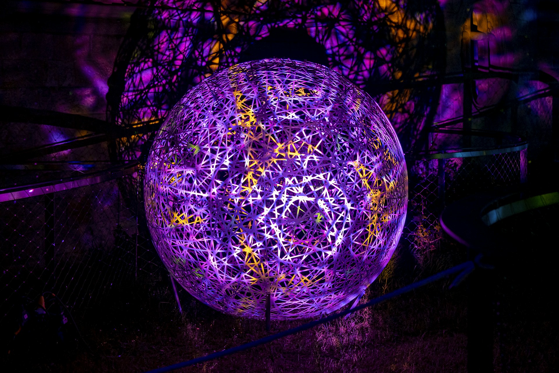 A striking sculpture blending metal and light, showcasing intricate technological details in a dark gallery setting.