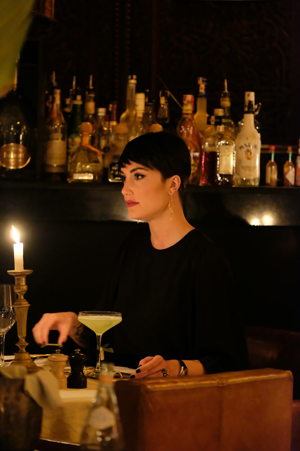 a woman sitting at a table with a drink