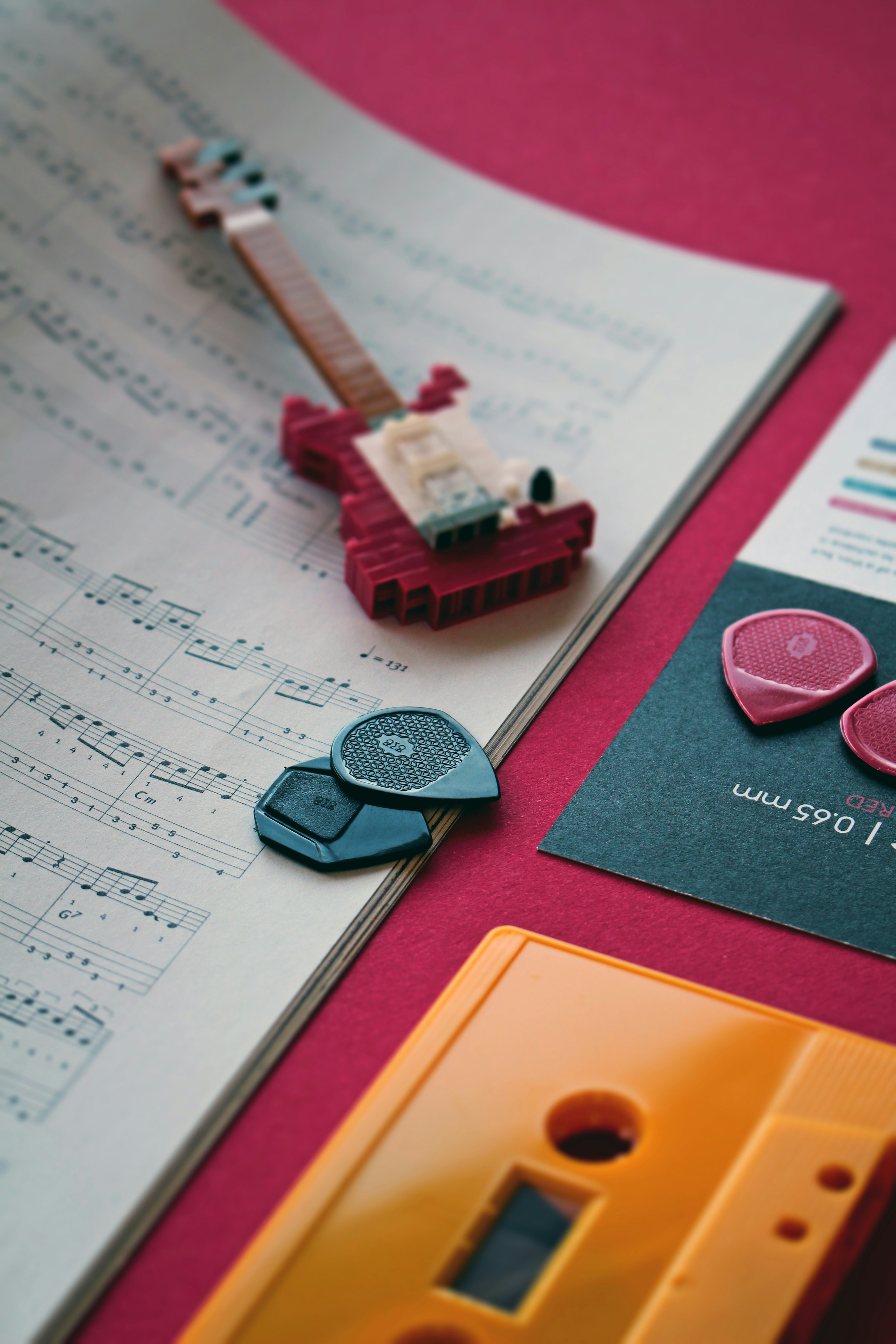 a pair of pink guitar picks sitting on top of a sheet of music