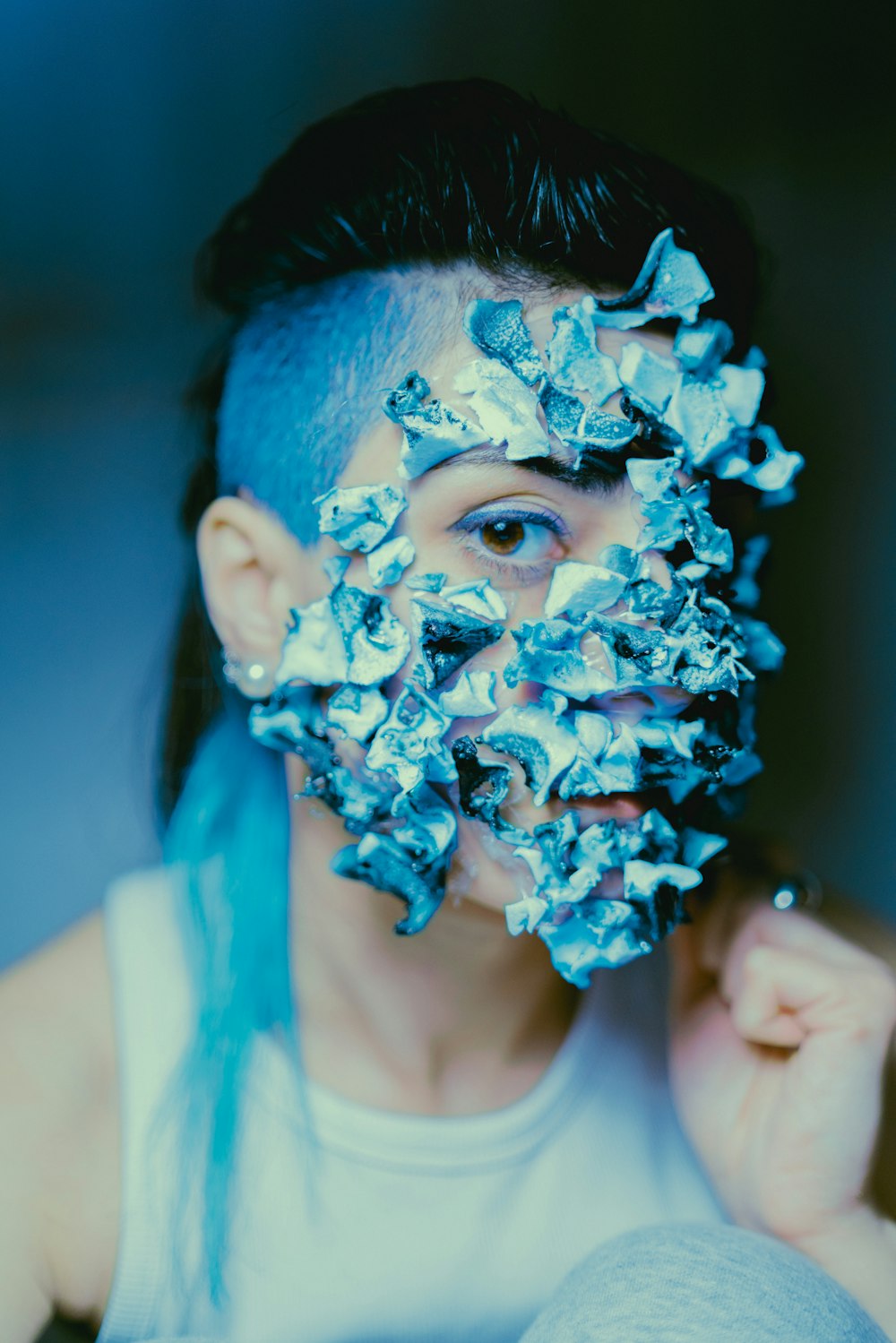 a woman with blue hair and a white shirt