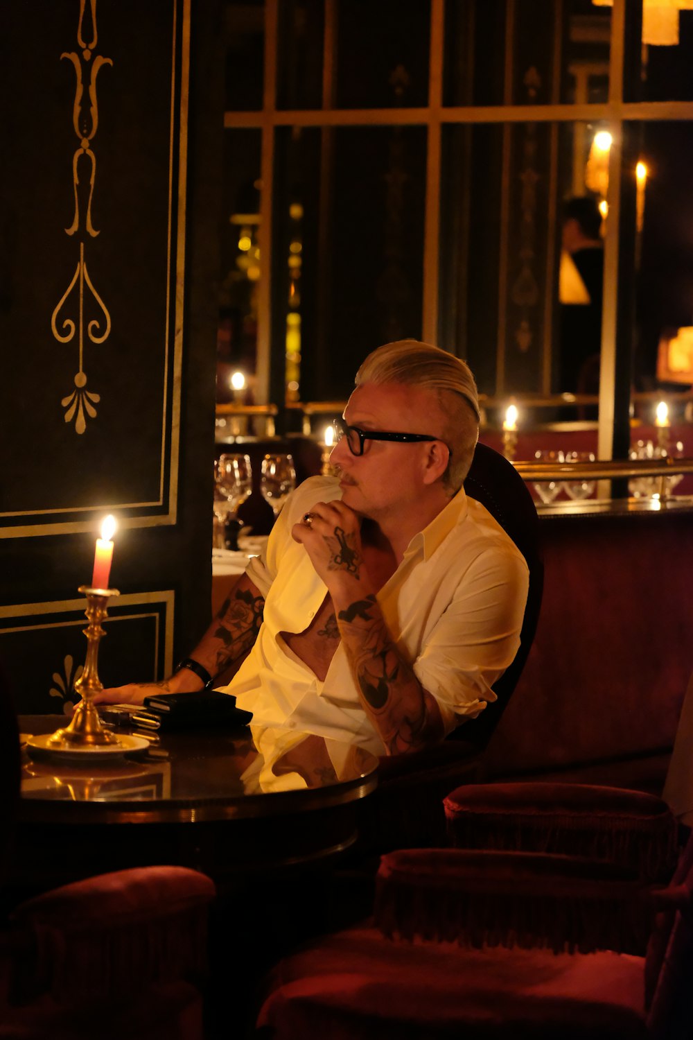 a man sitting at a table with a candle in his hand