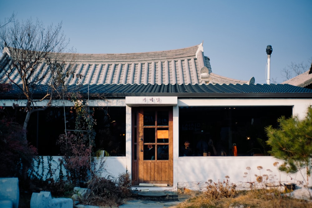 a white building with a wooden door in front of it