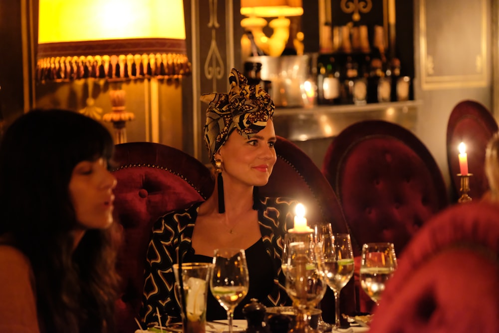 a woman sitting at a table with wine glasses