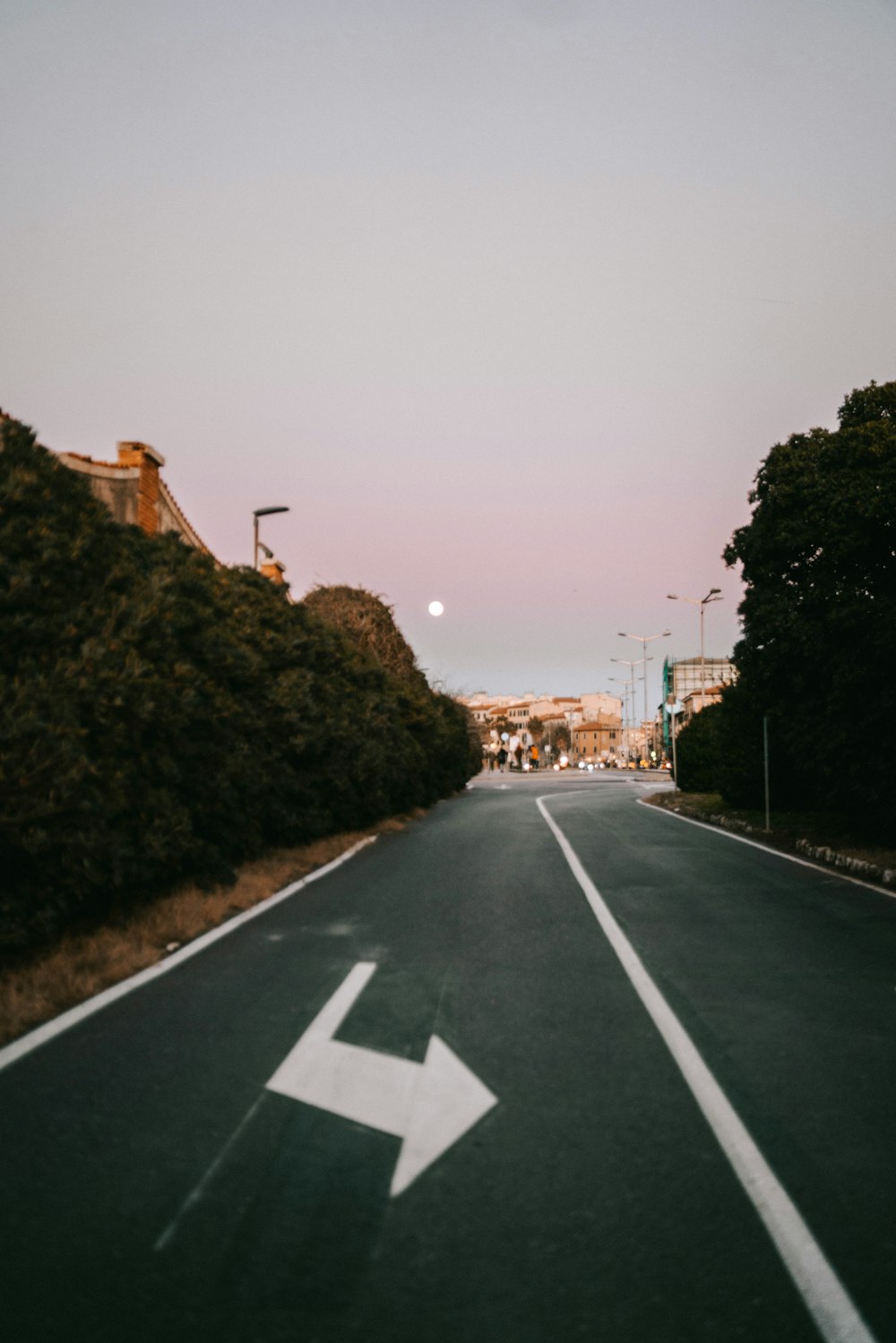 an empty street with a white arrow painted on it