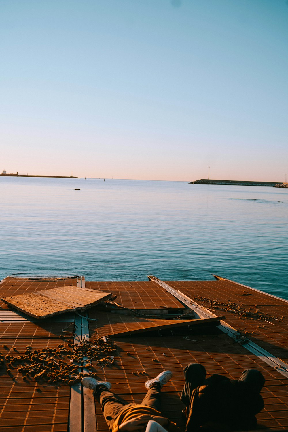 a person sitting on a dock with a view of the water