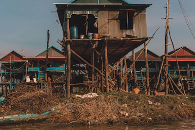 Stilted houses of a Cambodian floating village lit by warm evening light (via Unsplash)
