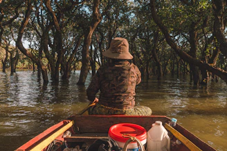 Photo of a rugged 16’ Carolina Skiff equipped with a camouflaged pop-up blind in a marsh at sunrise.